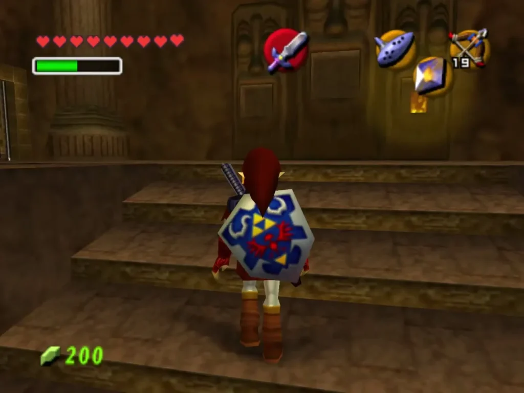 Link climbs the stone steps toward the torches and the door in the entrance hall