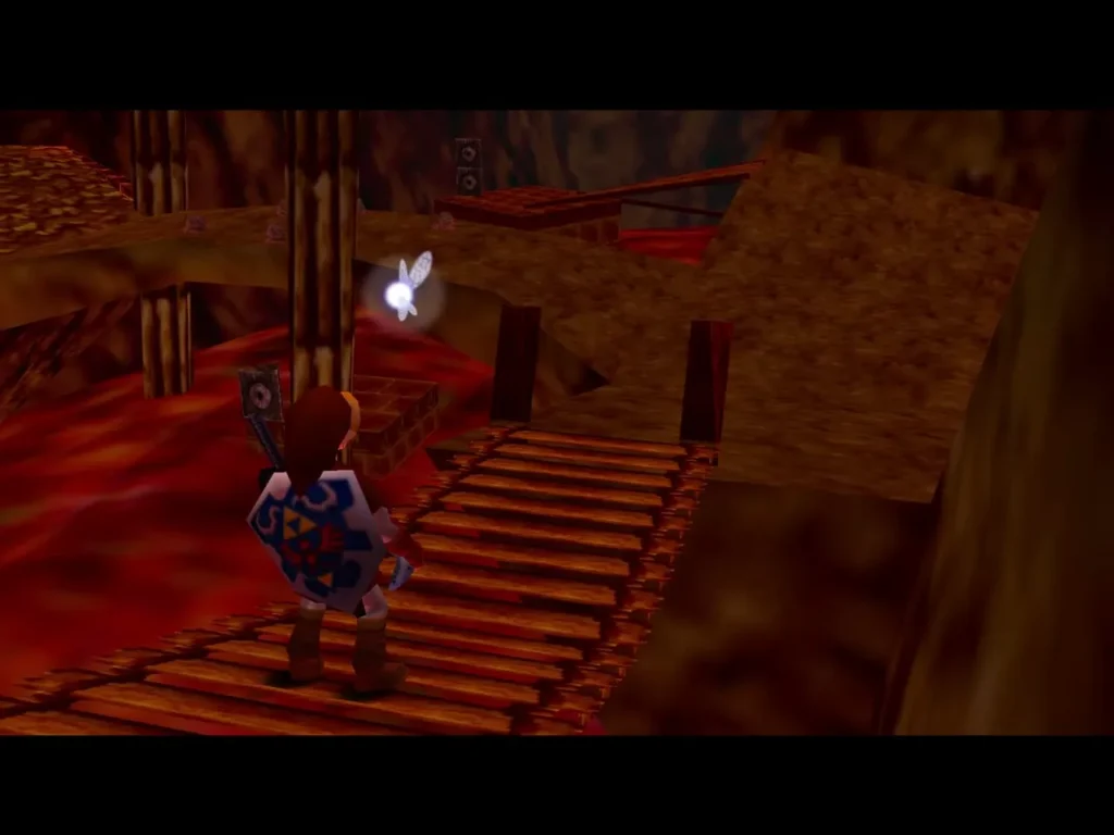 Link walks the wooden plank bridge over the lava toward the dark tunnel, a fairy ahead