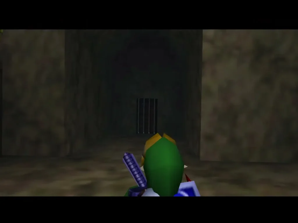 Link in a stone corridor facing a barred gate