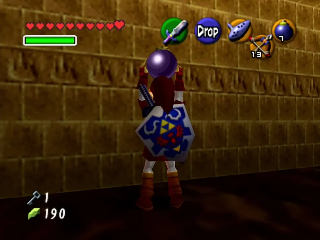 Link holding a Bomb overhead beside a dungeon wall in the Fire Temple Link holding a Bomb overhead beside a dungeon wall in the Fire Temple