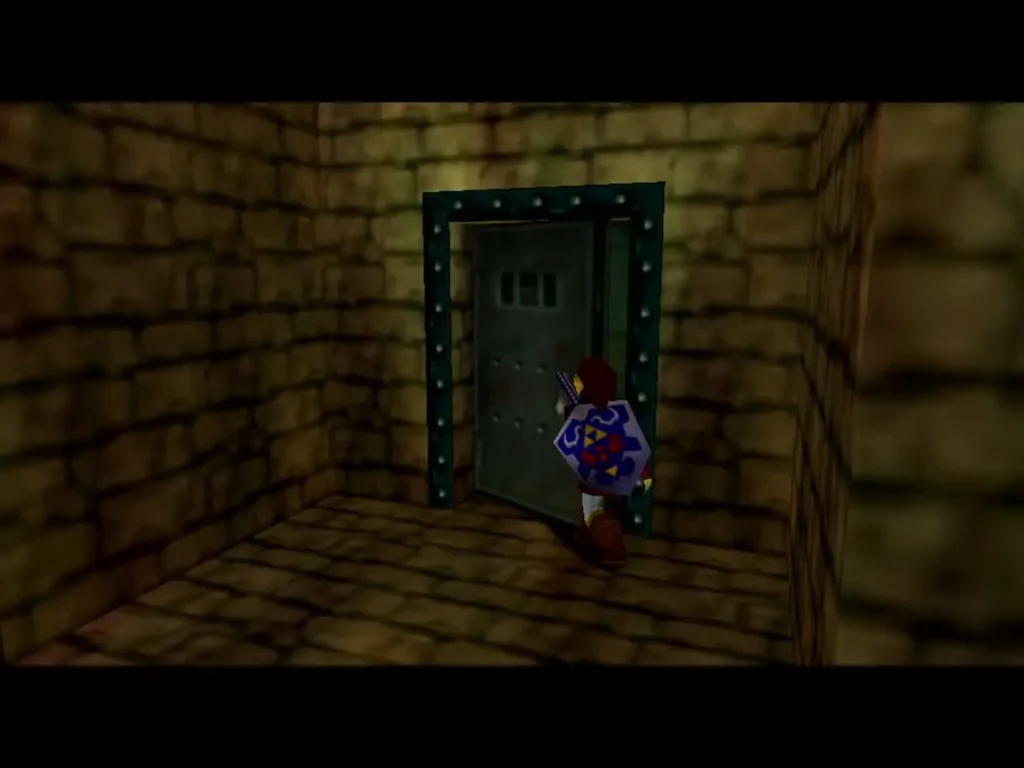 Link standing at the locked metal door in a stone corridor of the Shadow Temple Link standing at the locked metal door in a stone corridor of the Shadow Temple