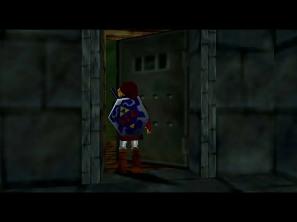 Link in a dark stone corridor walking toward a heavy iron gate in the Shadow Temple Link in a dark stone corridor walking toward a heavy iron gate in the Shadow Temple