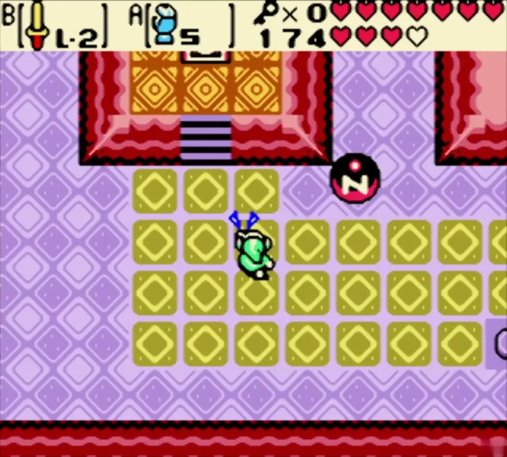 Link in the yellow-tile room of the cave with pink-and-red magnet blocks along the walls Link in the yellow-tile room of the cave with pink-and-red magnet blocks along the walls