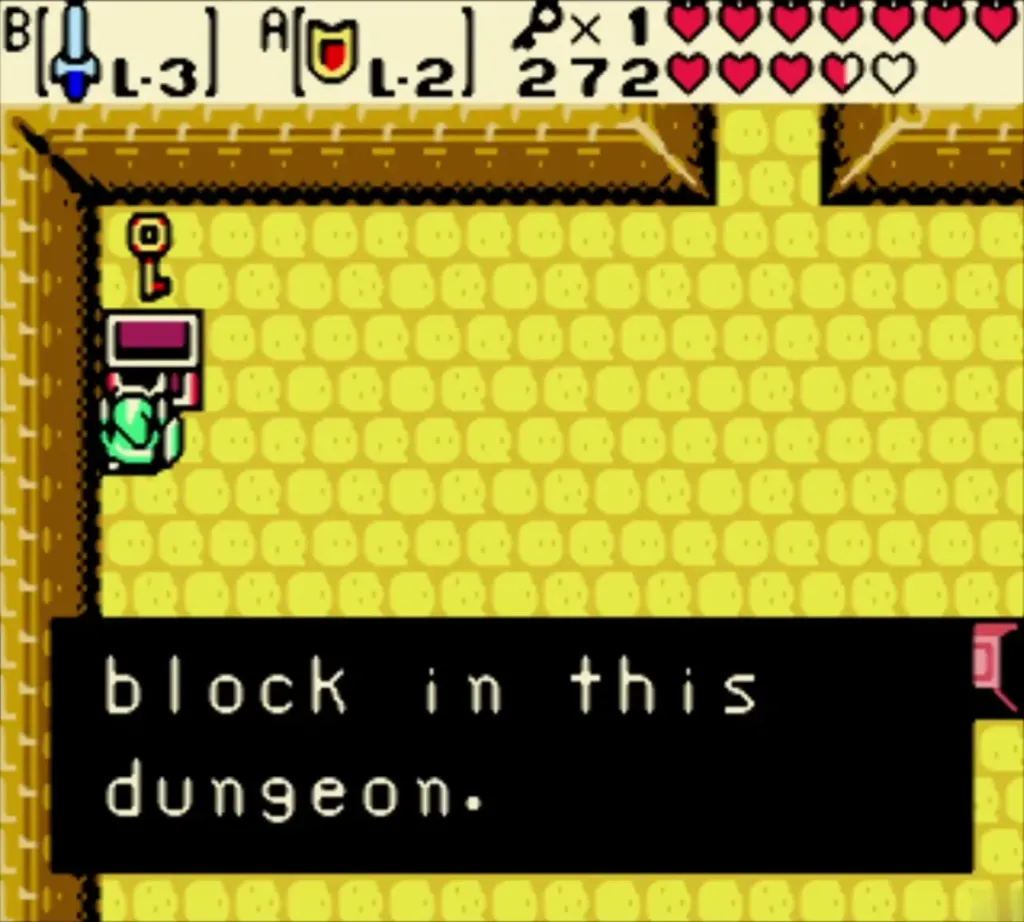Link holding up the Small Key from the chest, with the complete message "block in this dungeon." Link holding up the Small Key from the chest, with the complete message "block in this dungeon."