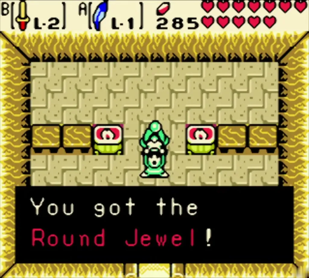 Link holding up the Round Jewel in the cave, with the item message fully shown