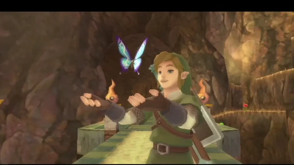 A Blessed Butterfly hovers in front of Link in a torchlit stone cave. A Blessed Butterfly hovers in front of Link in a torchlit stone cave.