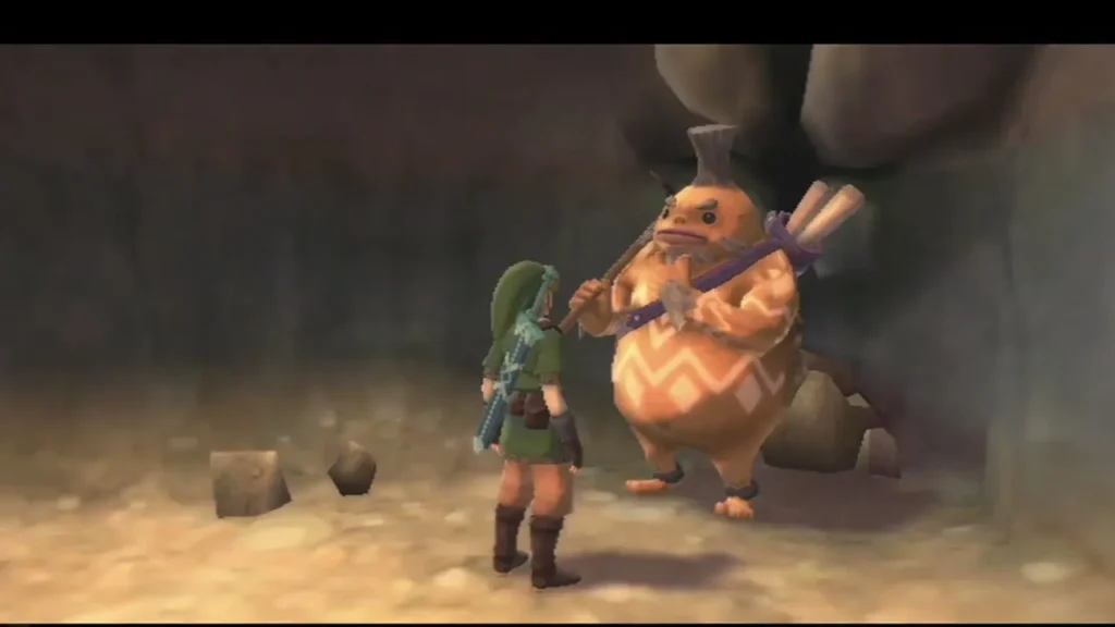 Link stands beside Golo, the round orange Goron, in a dim cave. Link stands beside Golo, the round orange Goron, in a dim cave.