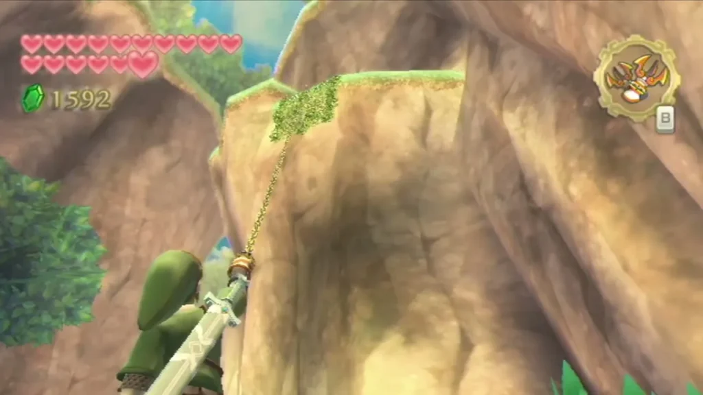Link fires the Clawshot at a patch of vines on a tall sandstone cliff near Lake Floria