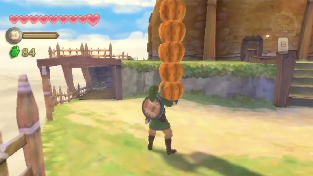 Link carries a tall stack of five pumpkins along a path beside a wooden fence and bridge. Link carries a tall stack of five pumpkins along a path beside a wooden fence and bridge.