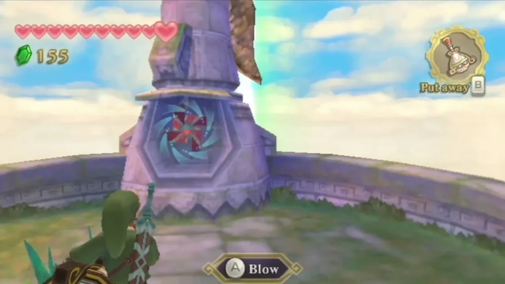 Link faces a windmill tower with a pinwheel face and a Blow prompt on the ground in front of it. Link faces a windmill tower with a pinwheel face and a Blow prompt on the ground in front of it.