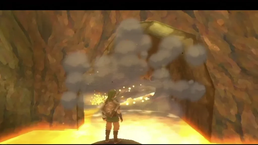 Link stands in a lava cave as a bomb blast breaks open a cracked rock wall.