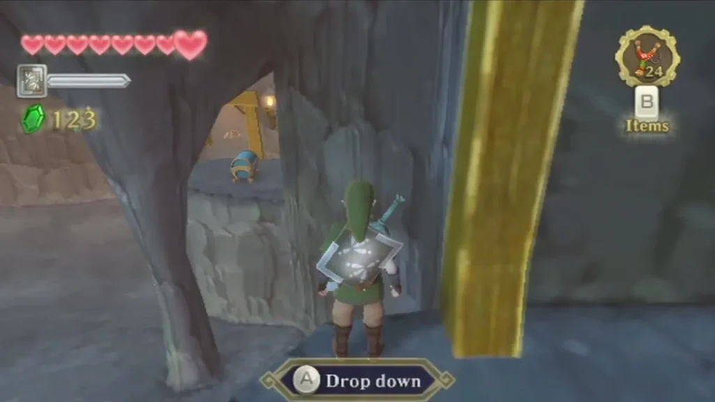After digging, Link stands on a higher ledge of the Eldin cavern, with a Drop down prompt on screen After digging, Link stands on a higher ledge of the Eldin cavern, with a Drop down prompt on screen