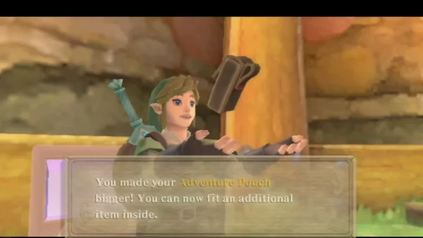 Link holds up his Adventure Pouch after its expansion, the box saying it can fit an additional item. Link holds up his Adventure Pouch after its expansion, the box saying it can fit an additional item.