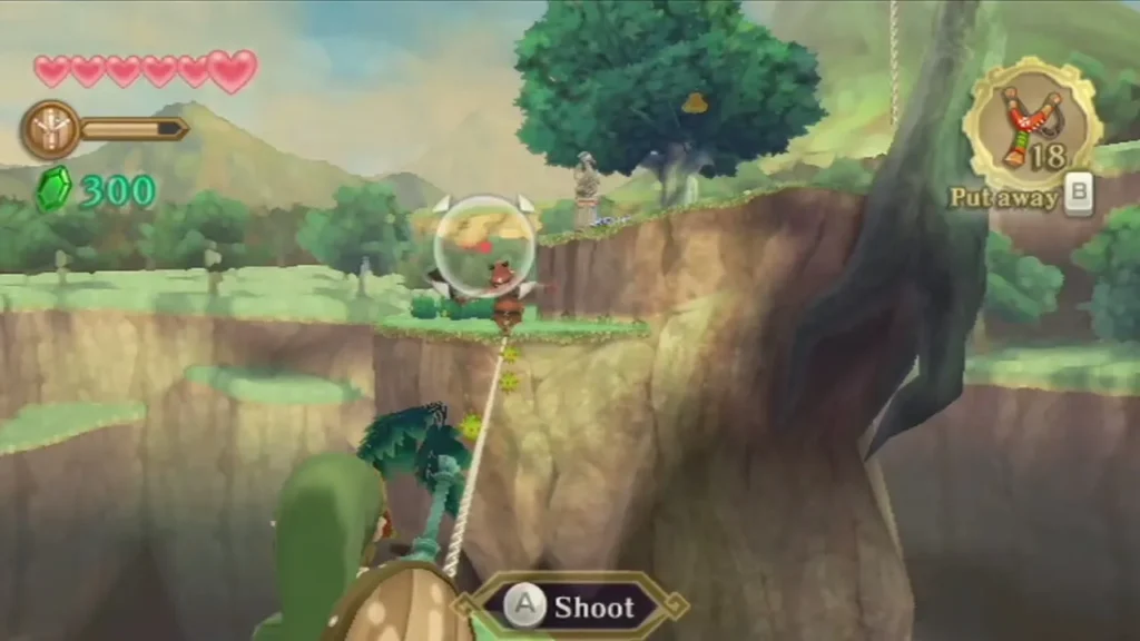 Link aims his Slingshot at a Bokoblin in a bubble on a ledge above a gorge, with the Shoot prompt on screen. Link aims his Slingshot at a Bokoblin in a bubble on a ledge above a gorge, with the Shoot prompt on screen.