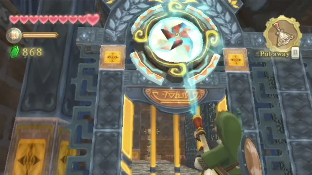 Link blows the Gust Bellows at a pinwheel set above a barred gate in the Mining Facility. Link blows the Gust Bellows at a pinwheel set above a barred gate in the Mining Facility.