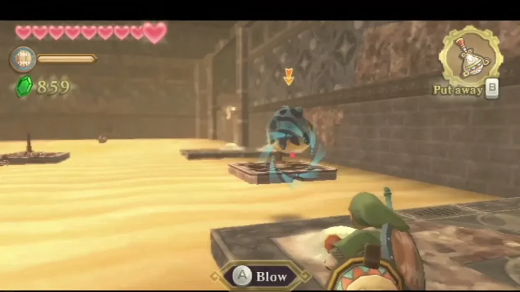Link is prompted to blow on a machine atop a sand platform in the Mining Facility's sand hall. Link is prompted to blow on a machine atop a sand platform in the Mining Facility's sand hall.