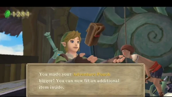 Link holds up the Adventure Pouch after the upgrade, with a box saying it can fit an additional item.