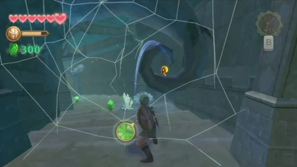 Link walks through a temple room hung with spider webs, near a green Rupee. Link walks through a temple room hung with spider webs, near a green Rupee.