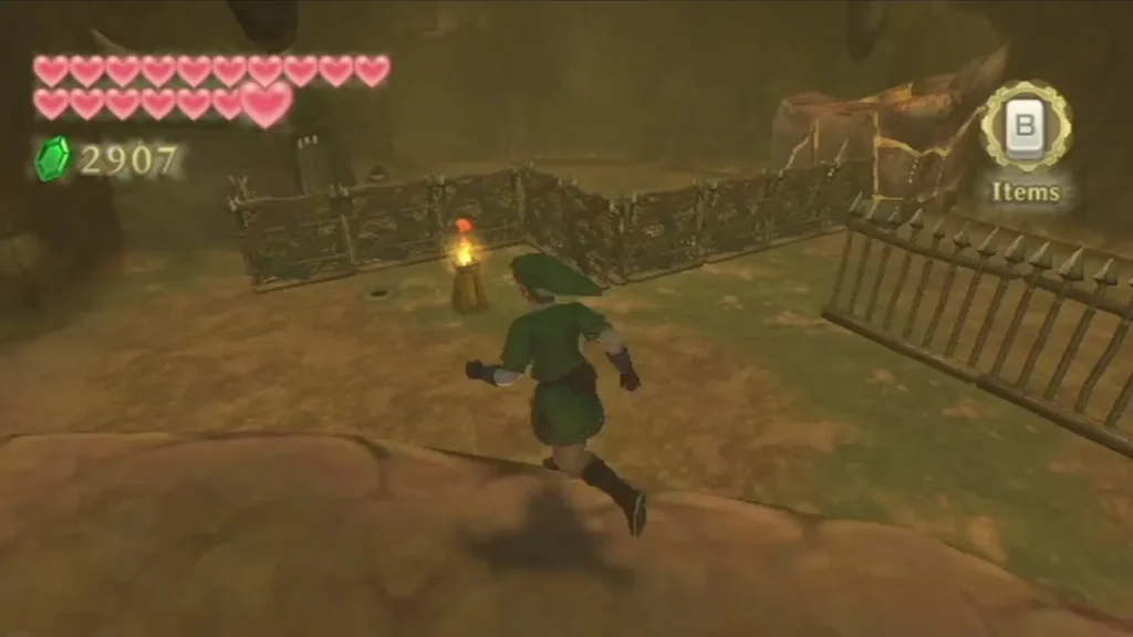 Link runs along a fenced lava-side path past a lit torch, with a spiked iron fence on the right.