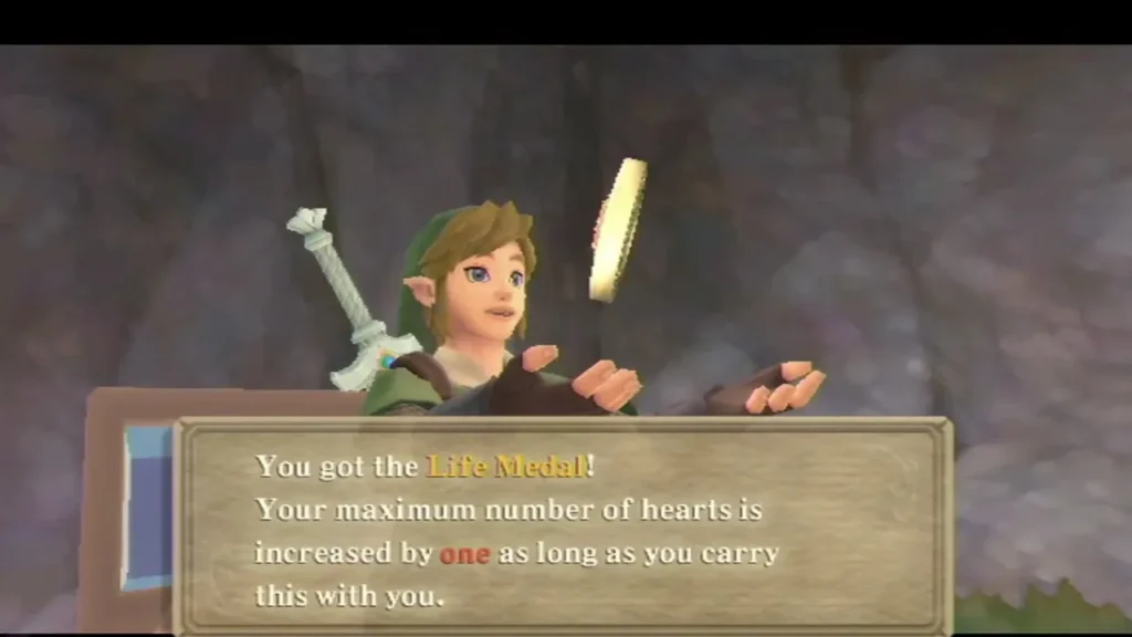 Link holds up the Life Medal, its box reading that max hearts rise by one while carried. Link holds up the Life Medal, its box reading that max hearts rise by one while carried.