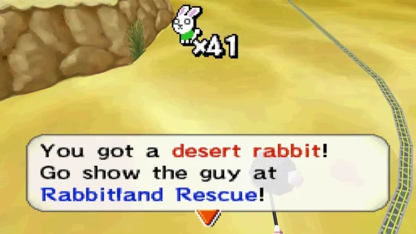You got a desert rabbit! message on sand with a rock wall at left and rails at right You got a desert rabbit! message on sand with a rock wall at left and rails at right