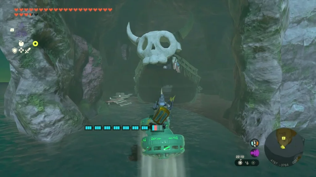 Skull-topped cave mouth seen from the water between rock pillars