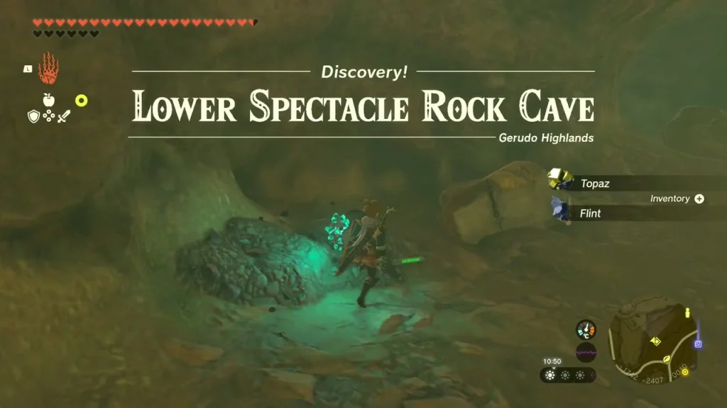 Low cave opening in the rocky canyon wall with a lit stone nearby Low cave opening in the rocky canyon wall with a lit stone nearby