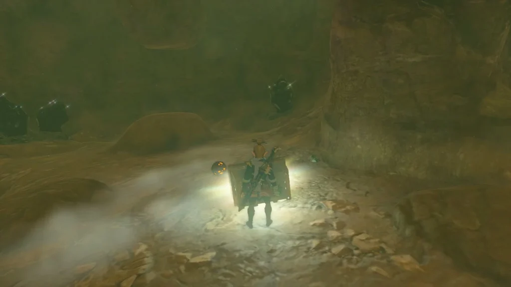 Treasure chest glowing on the cave floor beside a rock pillar Treasure chest glowing on the cave floor beside a rock pillar