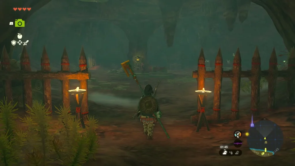 Wooden fence with lit torches across a cave mouth, lanterns glowing inside the hideout Wooden fence with lit torches across a cave mouth, lanterns glowing inside the hideout