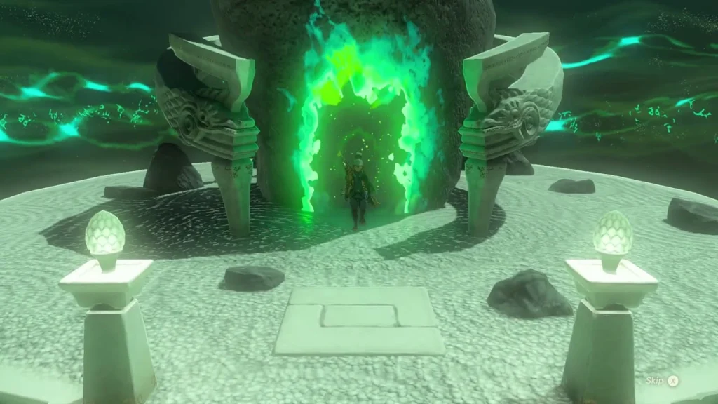 Circular platform with two lit pedestals and the glowing green doorway in the cave