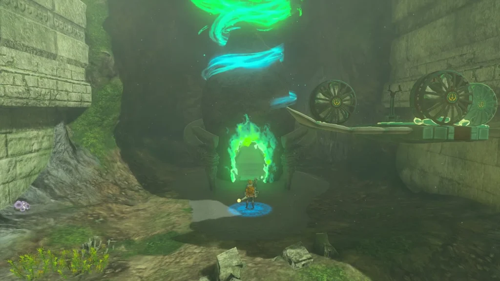 Shrine entrance glowing at the cave mouth beside a rail Shrine entrance glowing at the cave mouth beside a rail