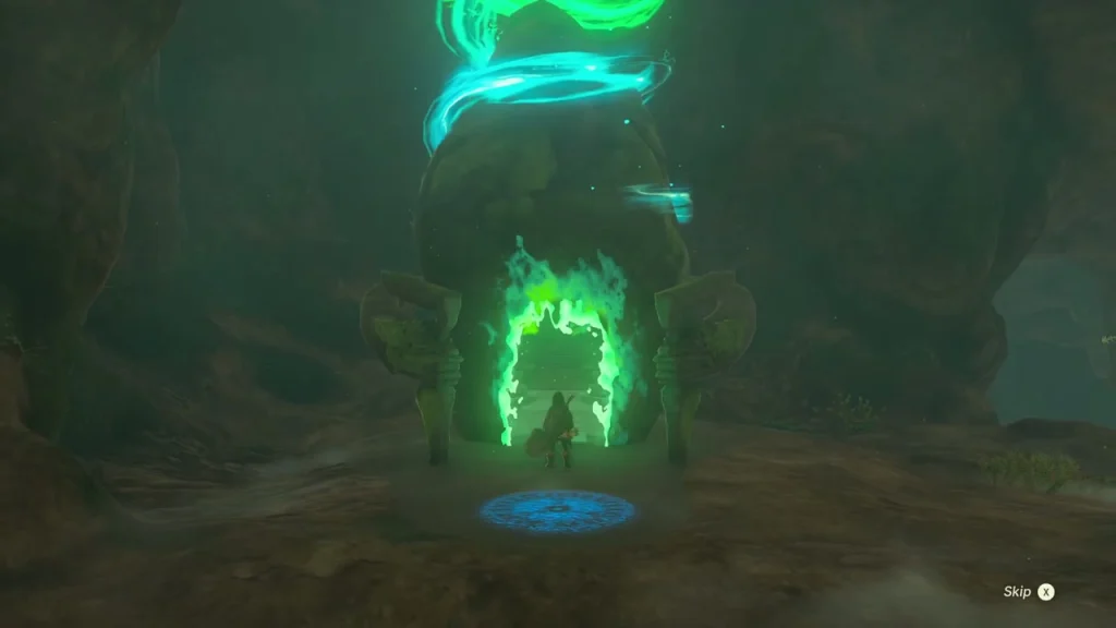 Glowing green shrine arch and blue entry platform at the top of the cave slope