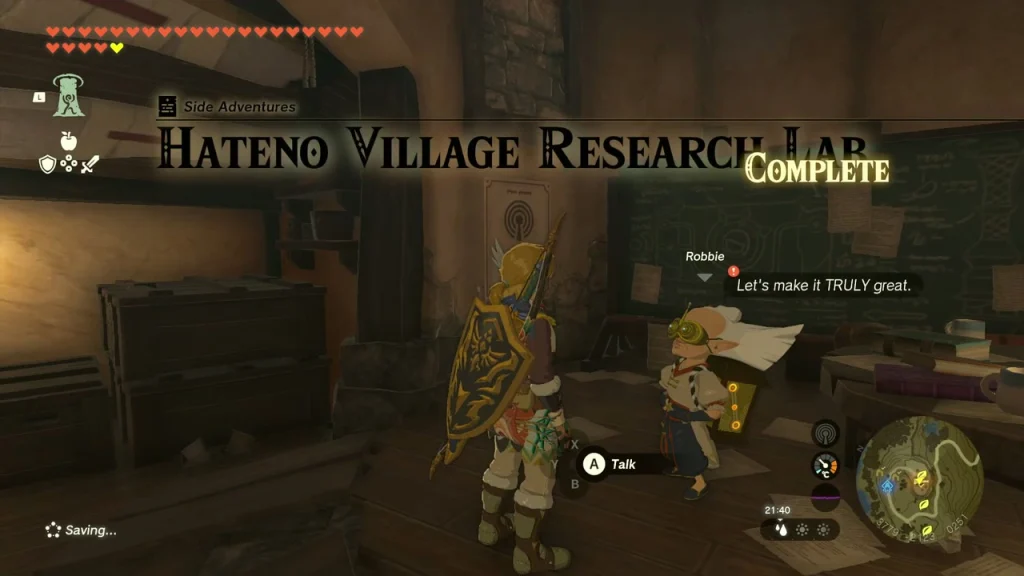 Robbie at his desk in the Hateno Village Research Lab, with the Talk prompt showing Robbie at his desk in the Hateno Village Research Lab, with the Talk prompt showing
