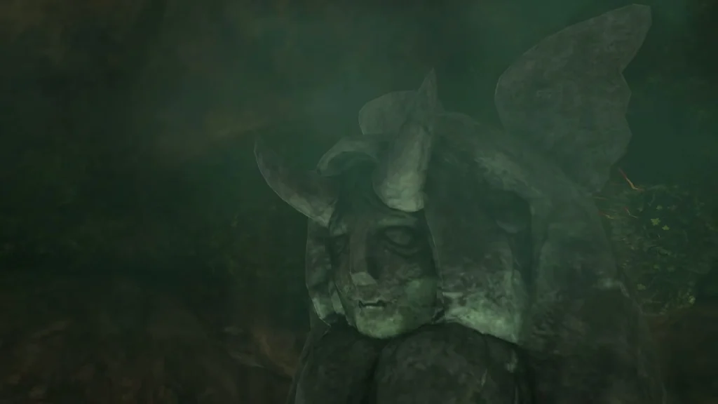 Moss-green horned statue half hidden behind the broken rock