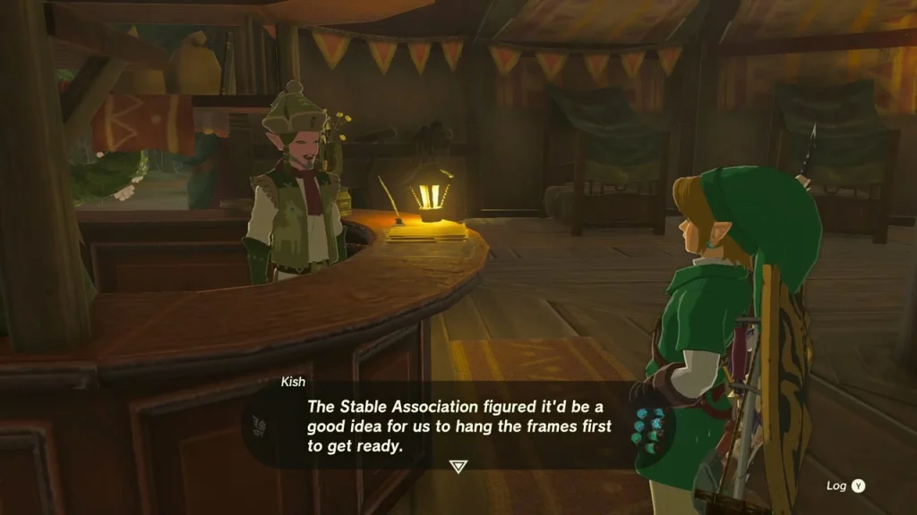 Kish behind the counter of Woodland Stable beside a lit lantern Kish behind the counter of Woodland Stable beside a lit lantern