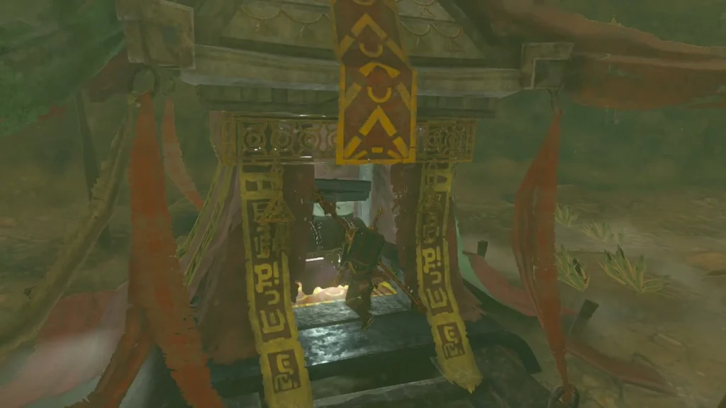 Banner-draped gate framing the treasure chest inside the statue cave