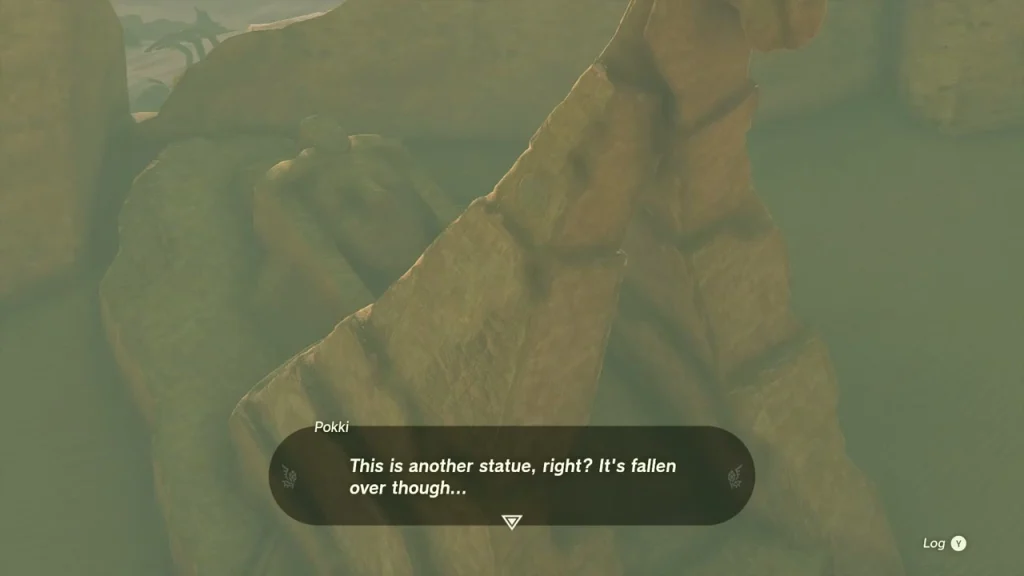 Fallen heroine statue lying in the sand at the ruins
