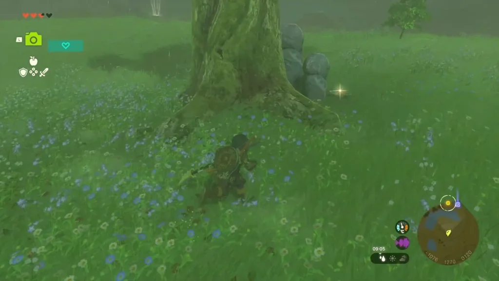 Huge tree with two stone statues at its roots in a flower meadow Huge tree with two stone statues at its roots in a flower meadow