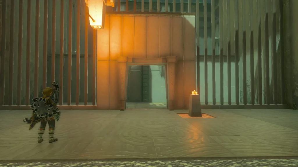 Barred gate in Karahatag Shrine with an upside-down torch above it and a lit pedestal beside it Barred gate in Karahatag Shrine with an upside-down torch above it and a lit pedestal beside it