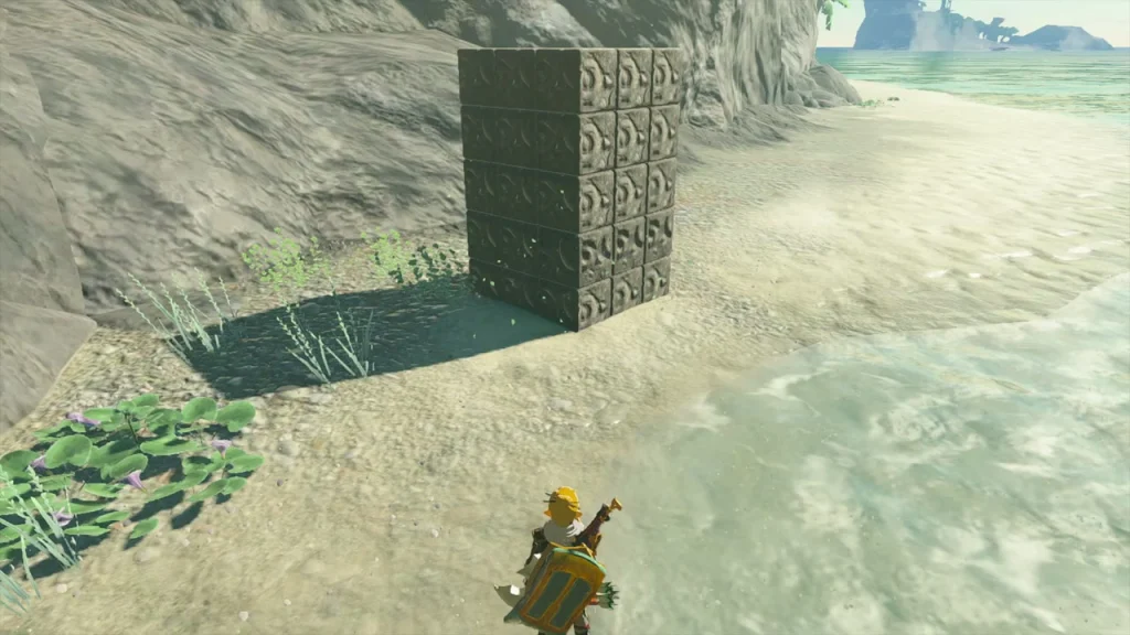 Wall of patterned cubes standing on the sand at the foot of the cliff Wall of patterned cubes standing on the sand at the foot of the cliff