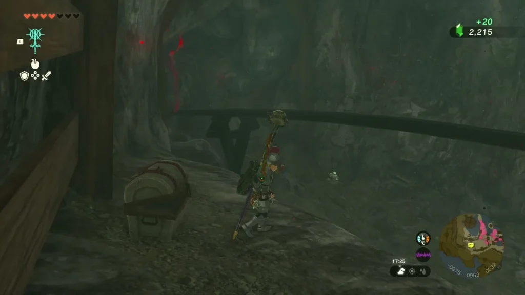 Opened chest on the rock floor beside wooden beams