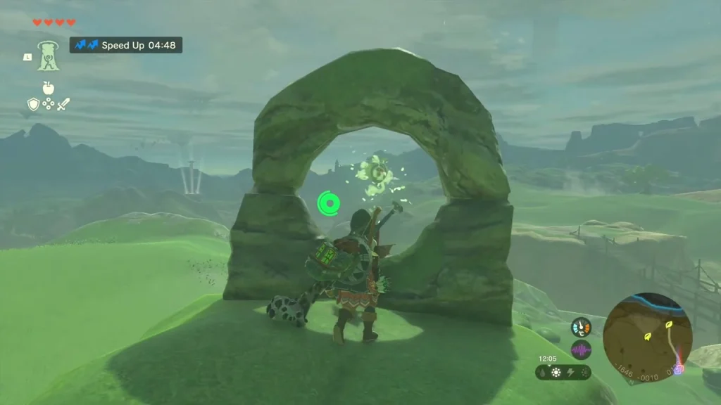 Mossy rock arch on a hillside with a balloon floating inside the ring