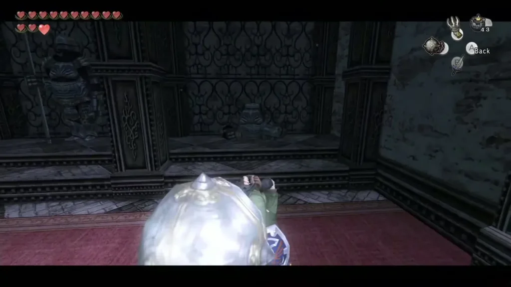Link swinging the Ball and Chain beside a suit of armor in the Snowpeak Ruins hall Link swinging the Ball and Chain beside a suit of armor in the Snowpeak Ruins hall